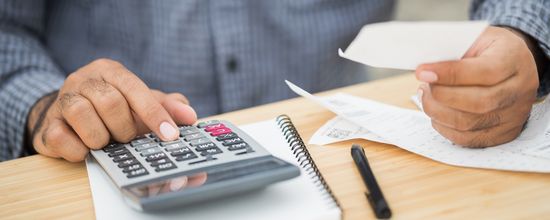 Man Working Out Costs Using Calculator