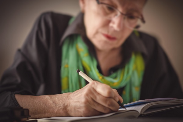Woman writing down her funeral wishes to give to family