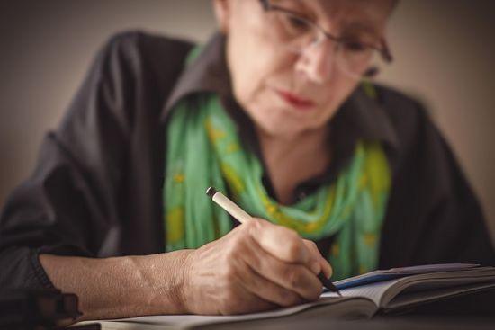 Woman writing down her funeral wishes to give to family