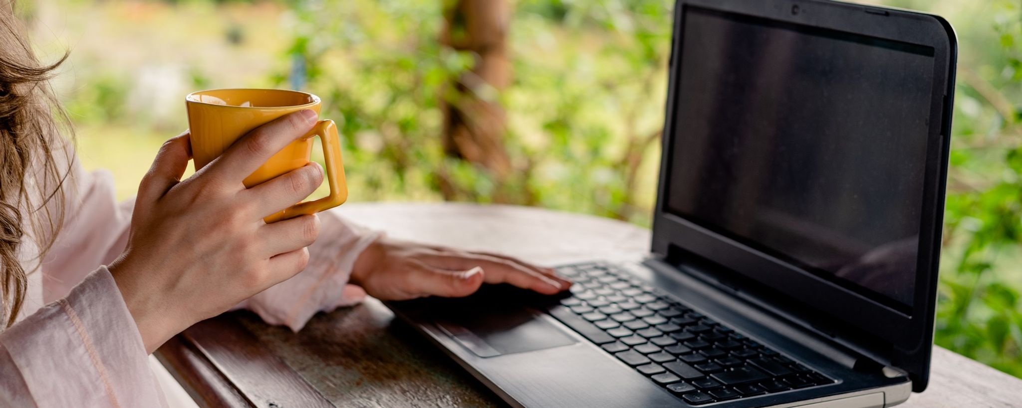 Lady Sitting In Garden With Laptop