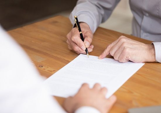 Man completing paperwork following with support