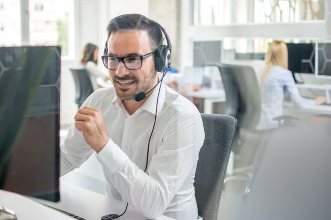Customer service agent smiling on phone in office