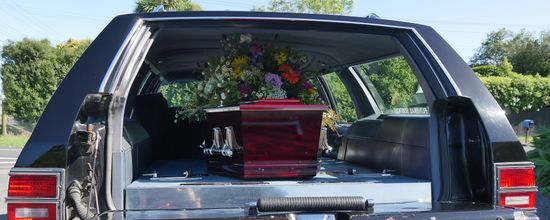 Coffin With Flowers In Hearse