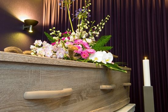 Simple wooden coffin with simple flower arrangement