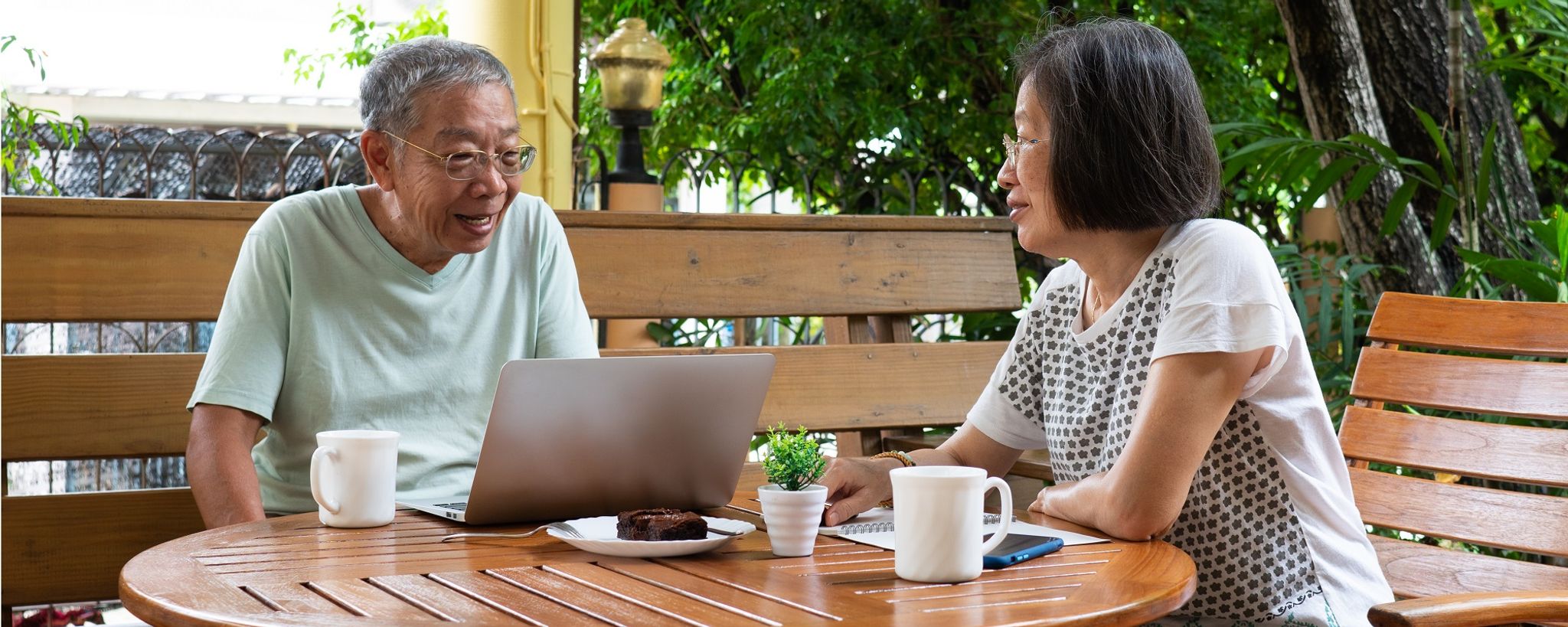 Older Couple At Table With Laptop