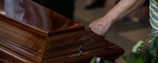 Mourner Touching Wooden Coffin
