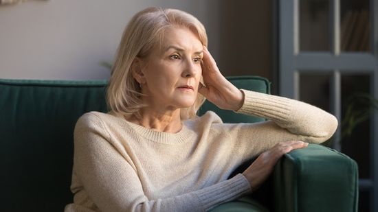 Woman sitting on chair, anxious about upcoming events while grieving