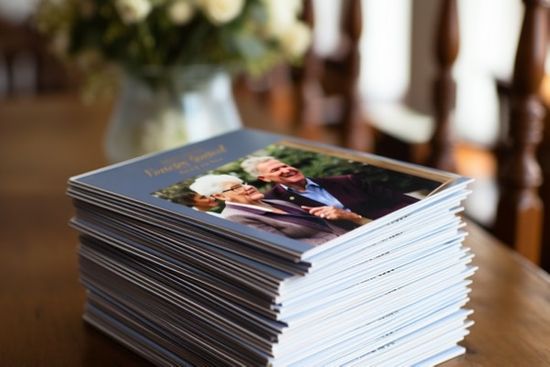 Stack Of Order Of Service Booklets On Table