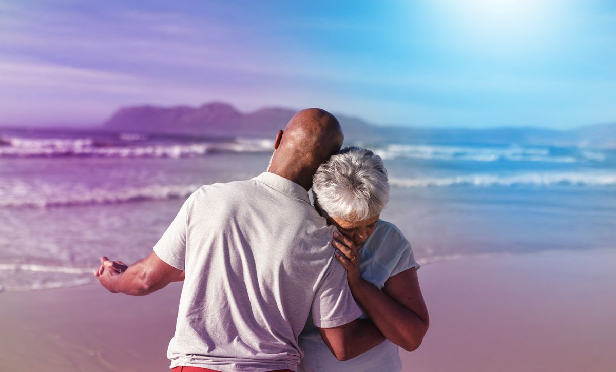 Older Couple Embracing By Beach