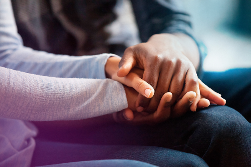 Comforting hands of grieving adult and child